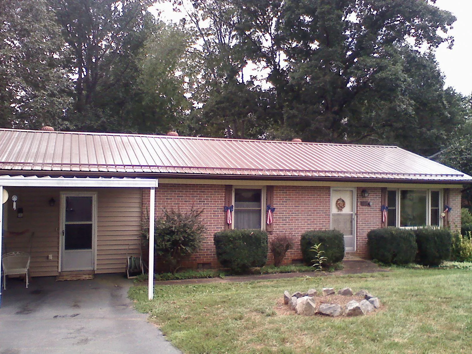 Bronze metal roof and carport on a brick ranch home — Roof Repair work by our crew in Roslyn